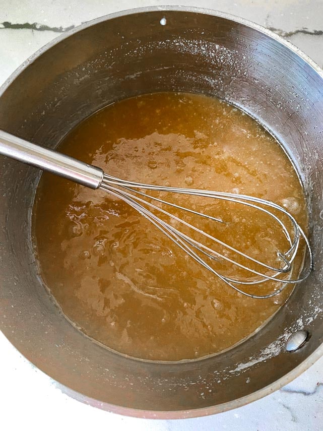 Whisking melted butter together with sugars in a pot