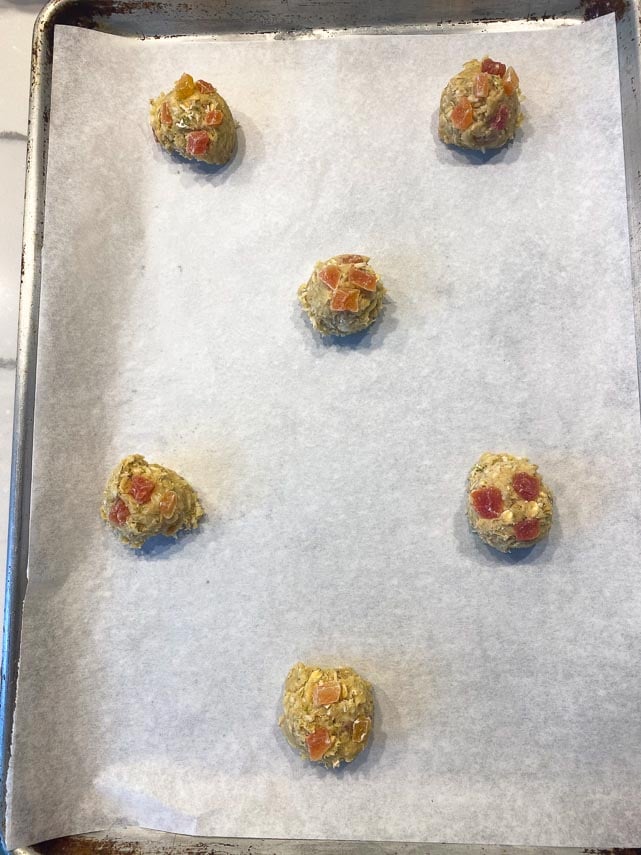 balls of oatmeal cookie dough on parchment paper lined pan, showing spacing