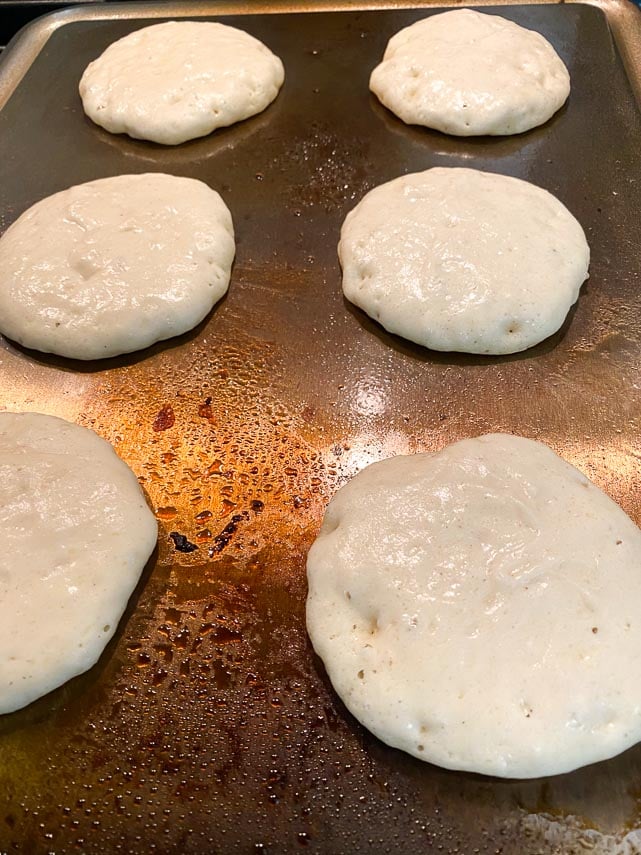 fluffy pancakes almost ready to flip over on griddle