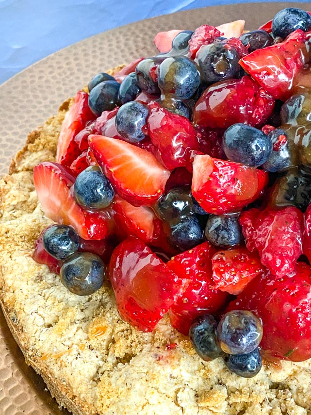 hazelnut shortcake with berries; close-up, on brass plate