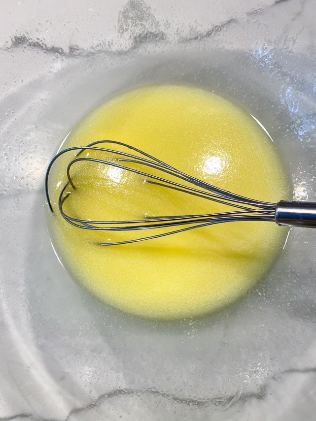 melted butter in clear glass bowl with whisk