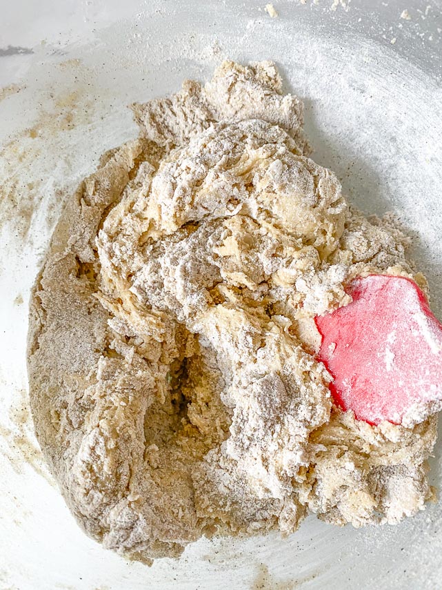 mixing flour about three-quarters of the way mixed in cookie dough