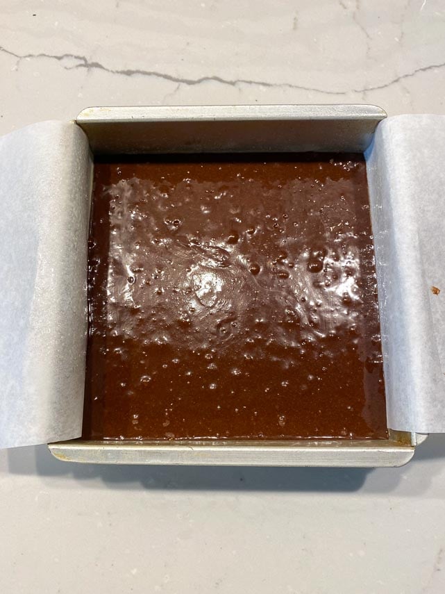 one bowl brownie batter in square pan lined with parchment paper