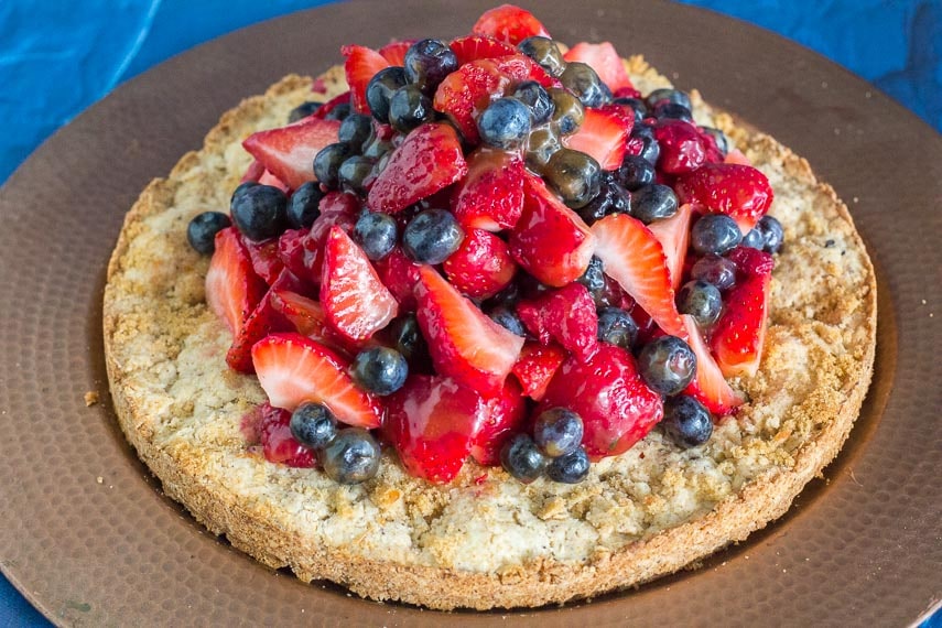 overhead hazelnut shortcake on brass platter with berries