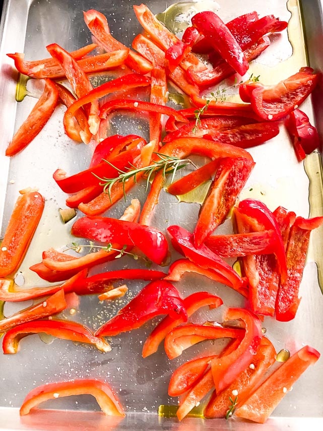 red bell pepper slices on sheet pan, drizzled with olive oil