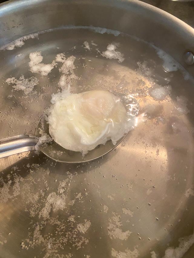 removing poached egg from water