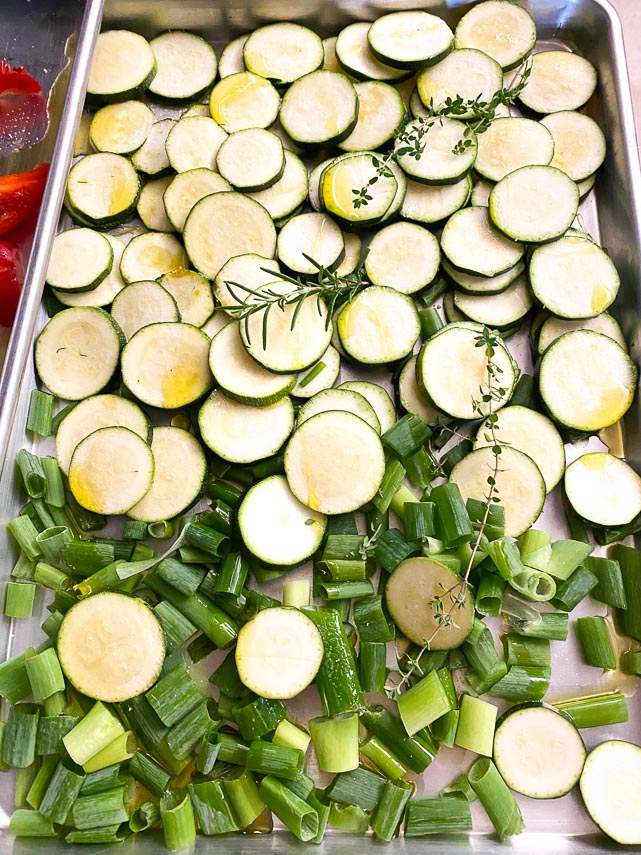 sheet pan holding sliced zucchini and chopped scallion greens for low FODMAP ratatouille