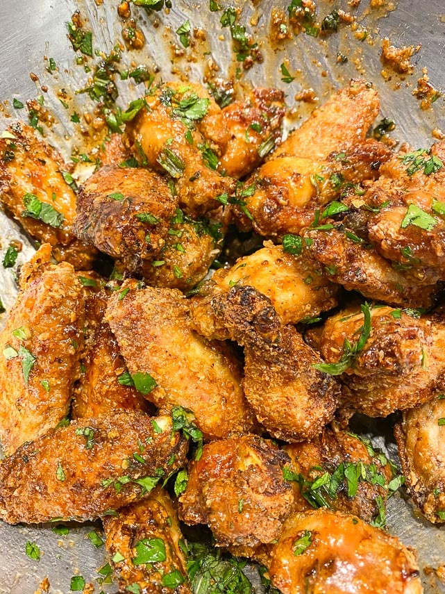 tossing wings with herbs in bowl