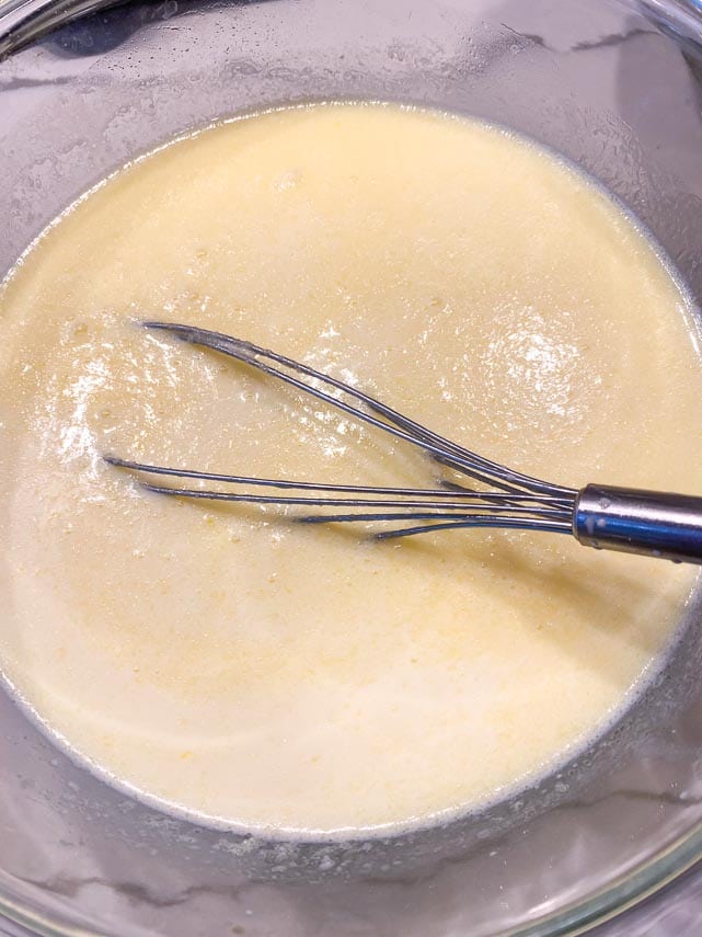 wet ingredients for fluffy pancakes in mixing bowl with whisk