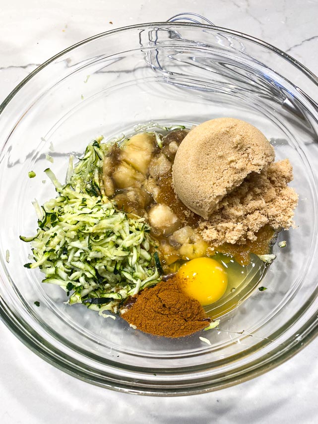 wet ingredients in clear glass bowl for zucchini banana bread