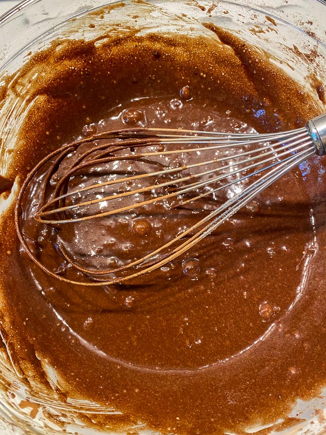 whisk cocoa into on bowl brownie mixture in glass bowl