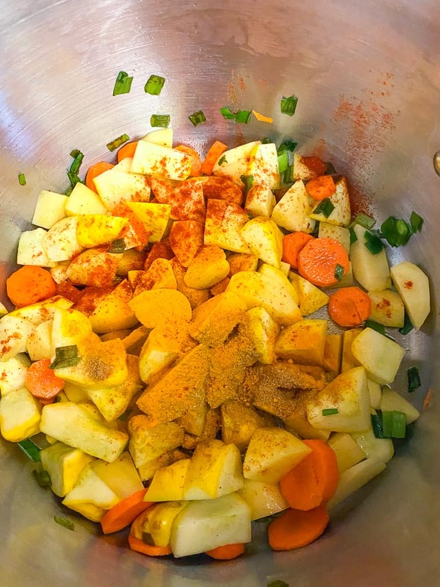 carrots, potatoes and patty pan squash cut into chunks, all together in a pot; adding spices to the mix