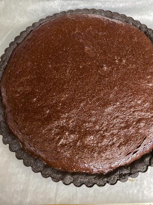 chocolate tart finished baking on parchment lined pan