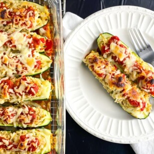 low FODMAP stuffed zucchini boats in glass baking dish and also alongside on white plate with fork
