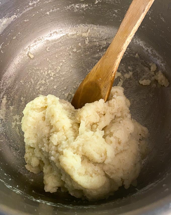 making pate a choux dough, in pot with wooden spoon