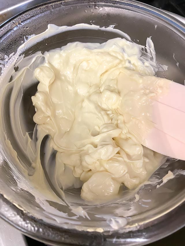 white chocolate melting in top of double boiler; pink silicone spatula