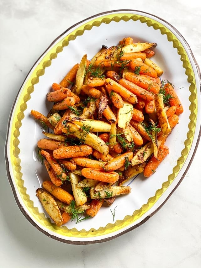Low FODMAP Carrots & Parsnips with Dijon Butter on white oval platter, sprinkled with Dill