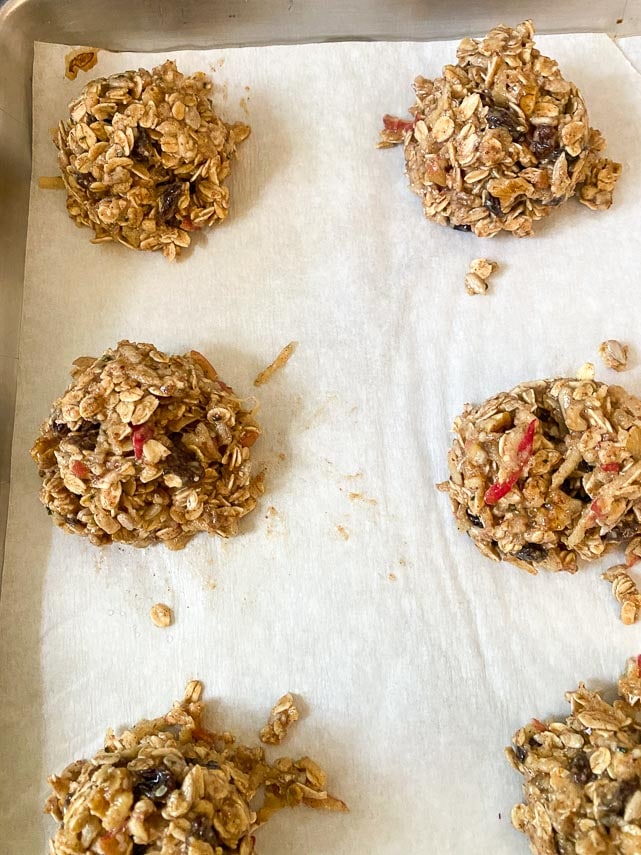 Apple oat breakfast cookie batter doled out onto parchment lined pan