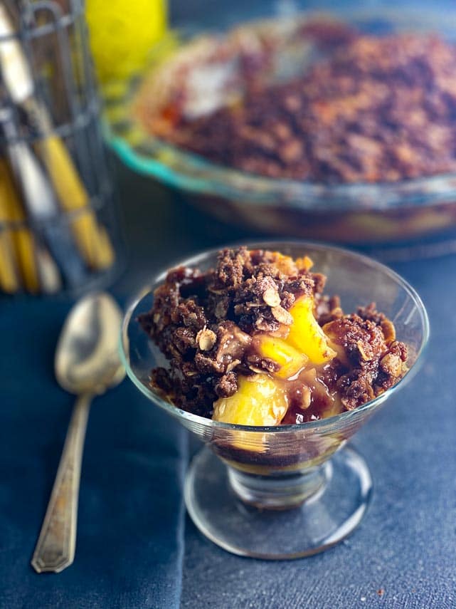 closeup-Low-FODMAP-Tropical-Crisp-in-a-glass-dish-with-chocolate-crisp-topping-dark-background