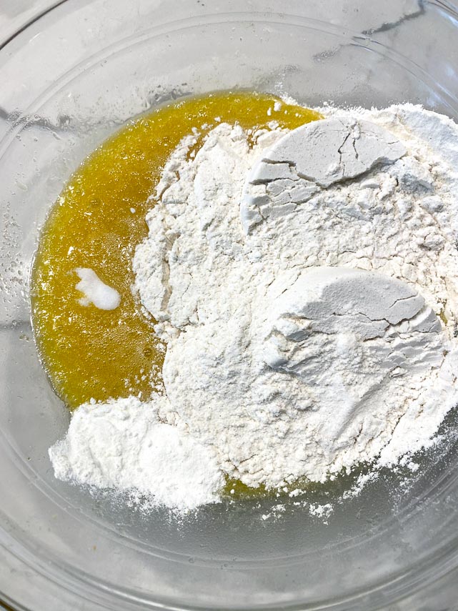 dry ingredients added to melted butter in glass bowl