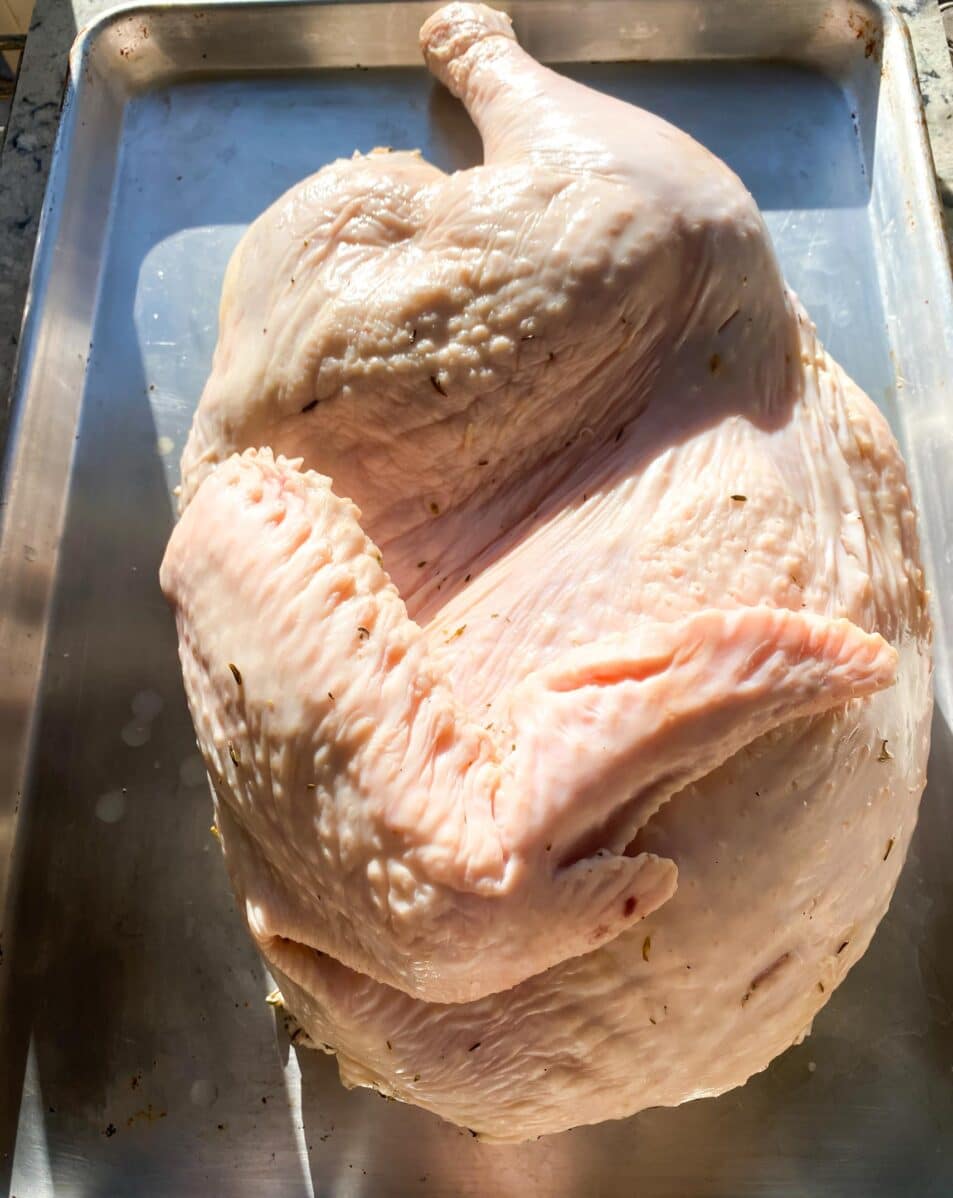 Half a turkey, post brining, on a half sheet pan.