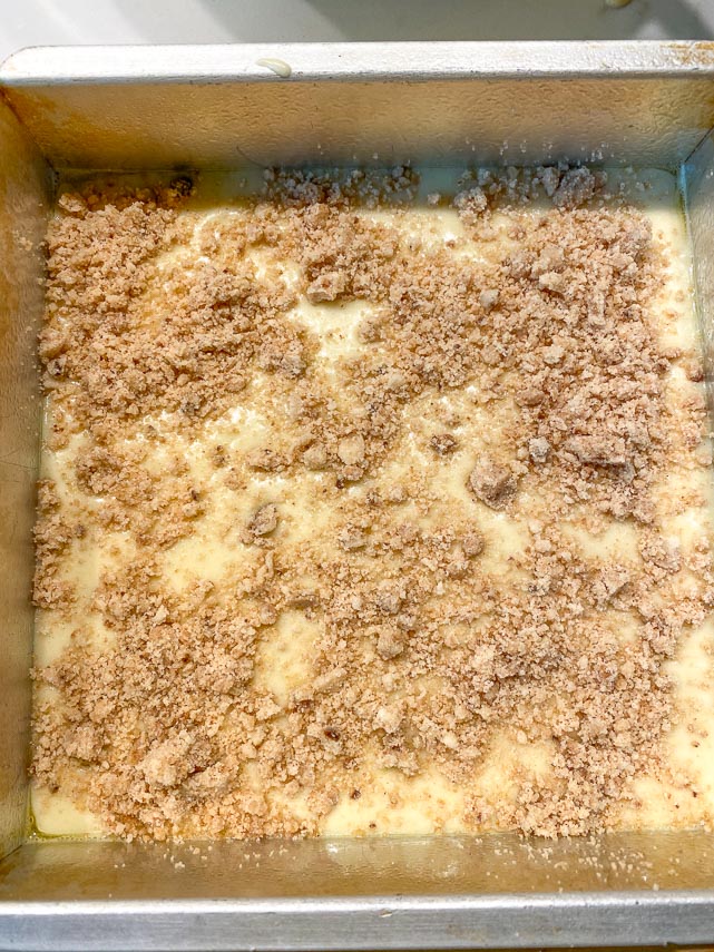 cake batter in square pan with streusel on top