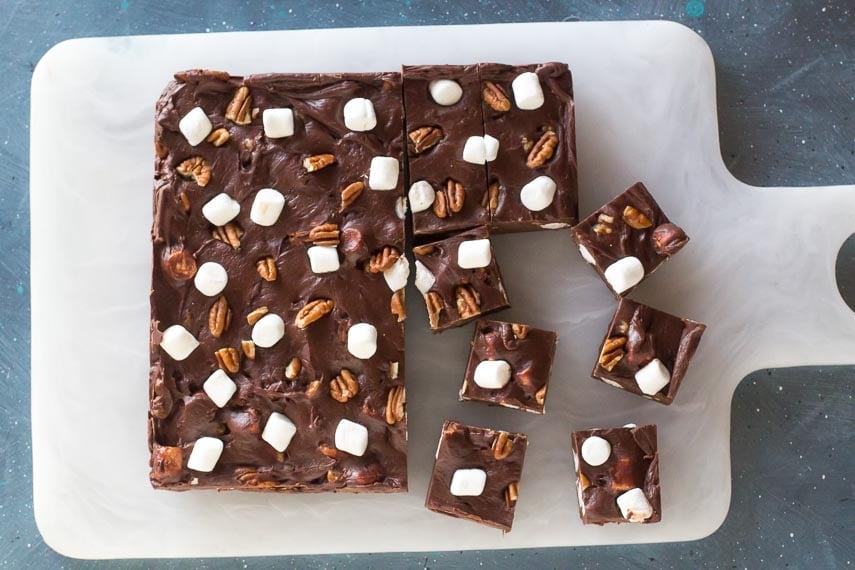 Low-FODMAP-Rocky-Road-Fudge-cut-into-squares-on-white-board-against-blue-background