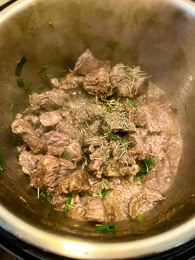 adding-dry-herbs-to-beef-stew-cooking-in-Instant-Pot