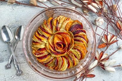 baked-root-vegetable-tian-in-glass-dish-on-white-painted-surface