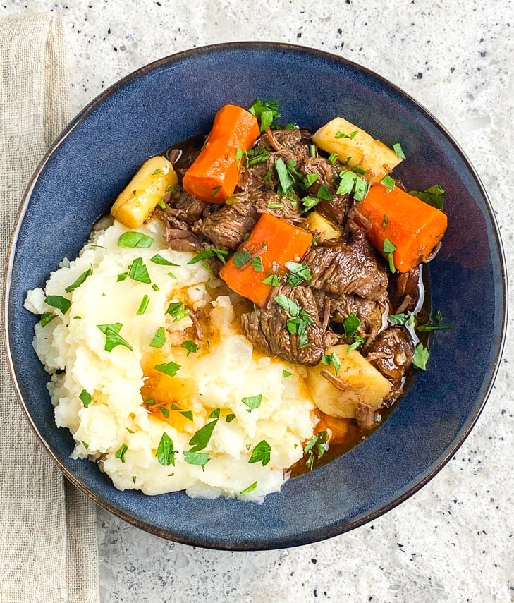 closeup-image-of-Low-FODMAP-Instant-Pot-Beef-Stew-in-blue-bowl-on-gray-background