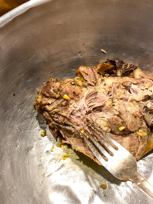 shredding-pork-with-a-fork-in-metal-bowl