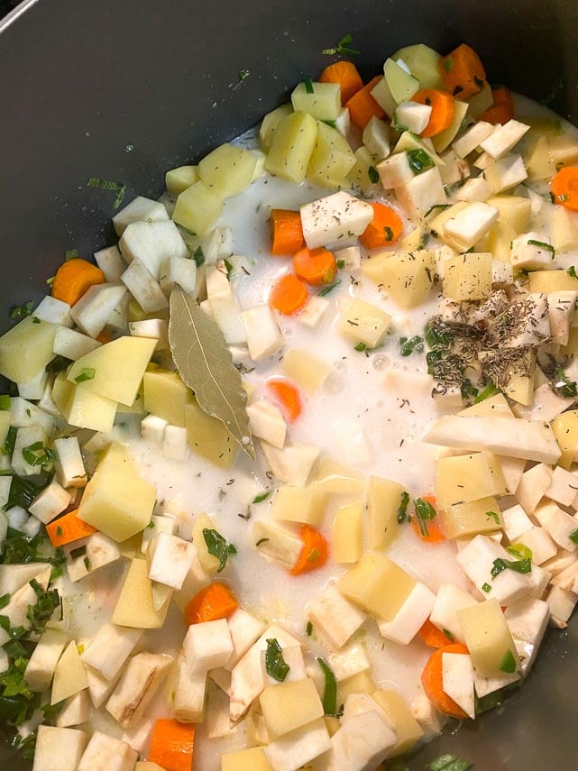 making-salmon-chowder.-Coconut-milk-added-to-pot-of-vegetables-with-thyme-and-bay-leaf