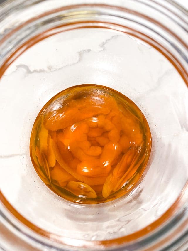 add-sugar-mixture-to-macerated-orange-peels-in-glass-jar