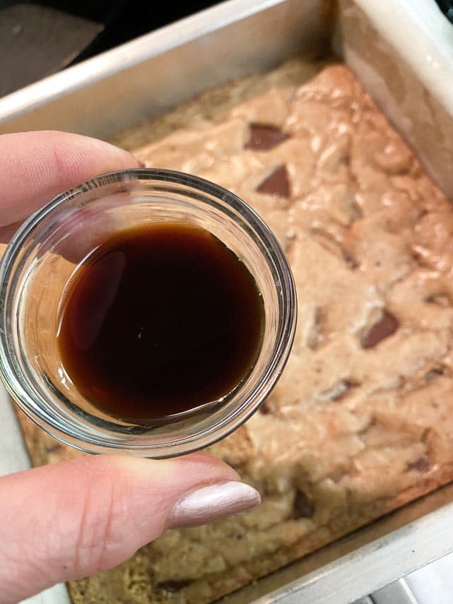 coffee-liqueur-held-in-small-bowl-about-to-be-brushed-on-blondies-that-came-out-of-the-oven