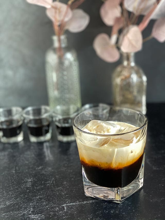 making-a-white-russian-with-low-FODMAP-coffee-liqueur-in-rocks-glass-with-ice-on-dark-background