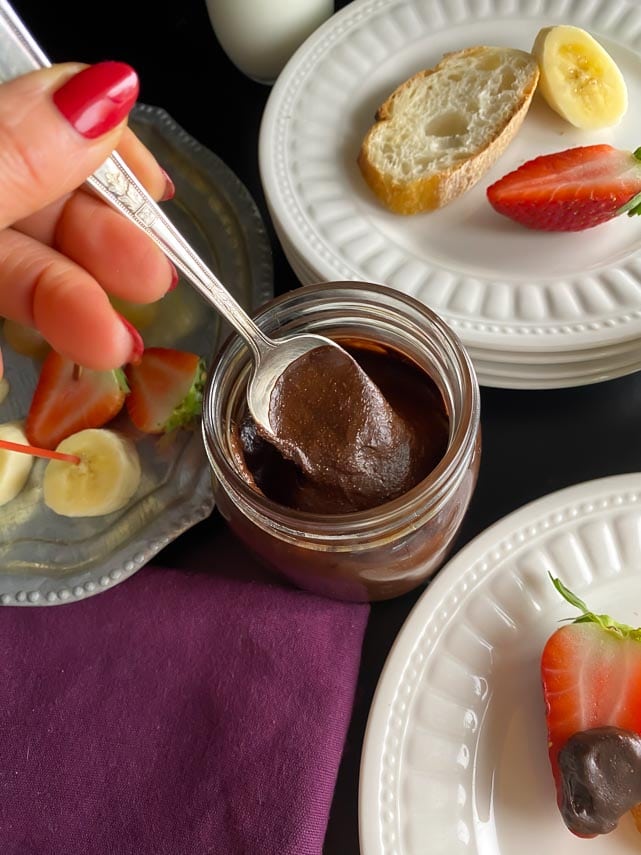 Nutella on spoon in glass jar