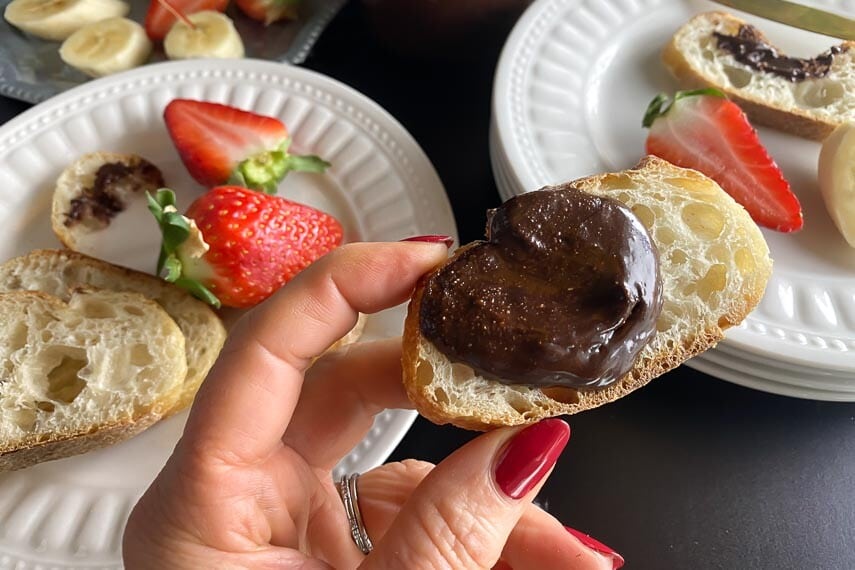 closeup of low FODMAP Nutella on bread, held in manicured hand
