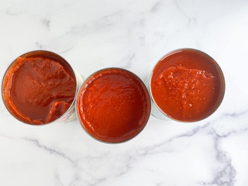 looking down into cans of tomato purée and crushed tomatoes