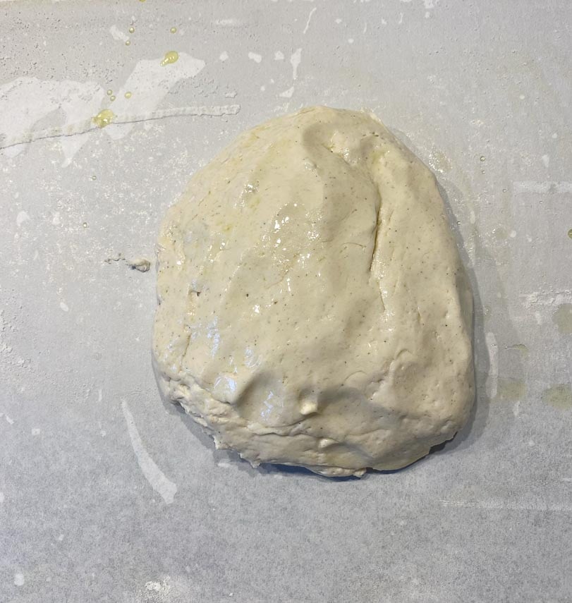 oiled fingers can smooth out pizza dough on pan