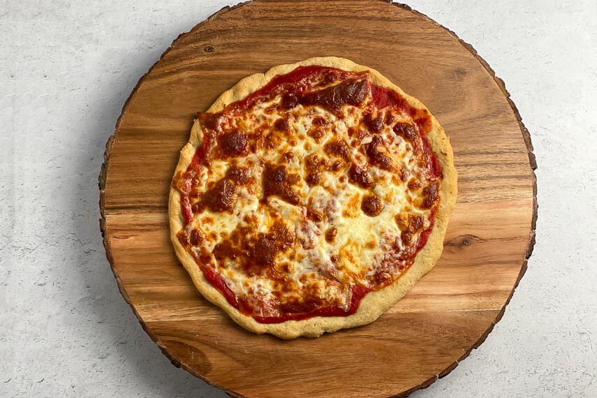 overhead horizontal image of Low FODMAP Pizza on wooden board; gray background