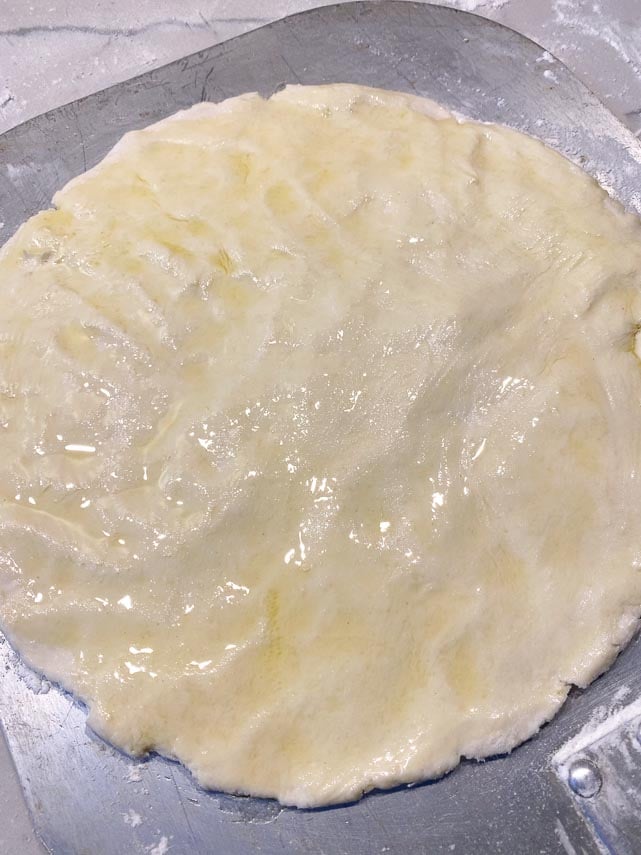 pizza 2.0 dough patted out on flour dusted pizza peel