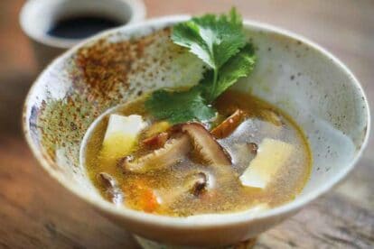 close up of tofu mushroom soup in rustic bowl