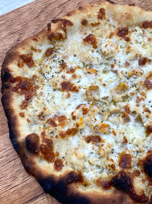 clam pizza on wooden board
