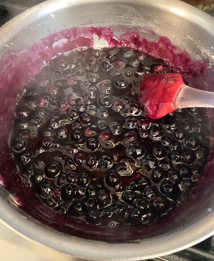 cooking blueberries in a saucepan until jammy
