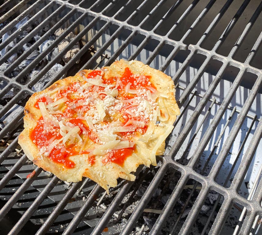 grilled pizza dolloped with tomato sauce and Fontina and Pecorino on grill-2