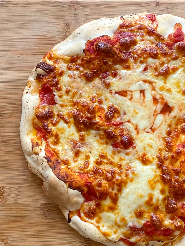 vertical close up of close up of Caputo Fioreglut gluten free pizza crust on wooden board