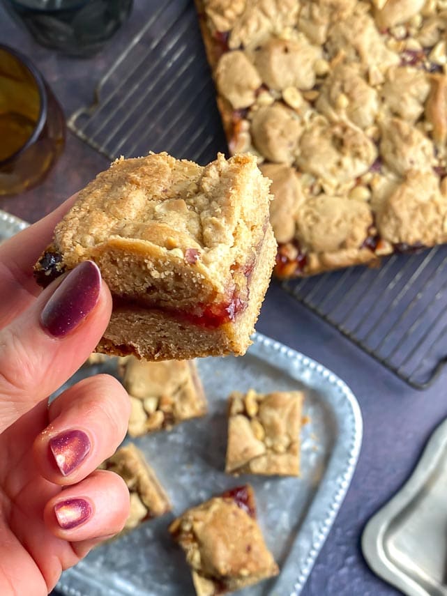peanut butter and jelly bar held in manicured woman's hand
