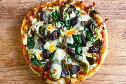 Low FODMAP sourdough pizza topped with vegetables on board