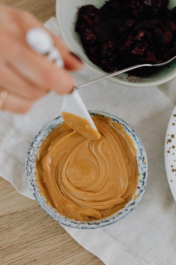 woman stirring peanut butter in jar