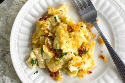 Main image Low FODMAP Chicken & Bacon Ranch Mac and Cheese on white plate with fork; grey quartz surface